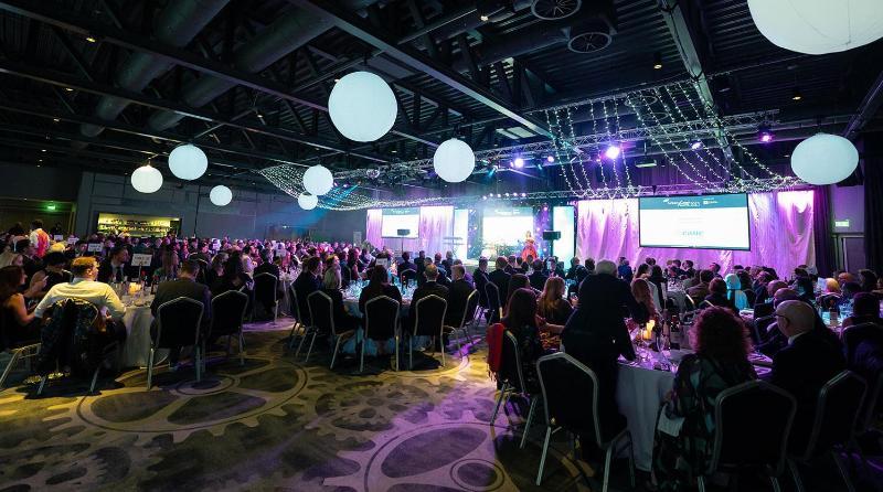 A room full of people at tables at an awards ceremony
