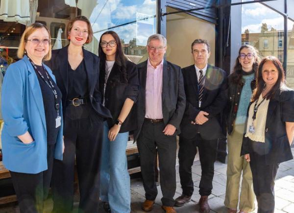 A group of people stood in front of a storefront