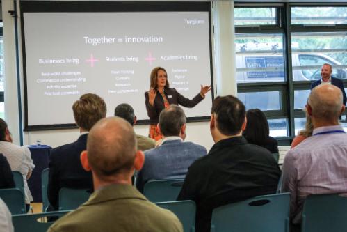 An audience listens to a person giving a talk