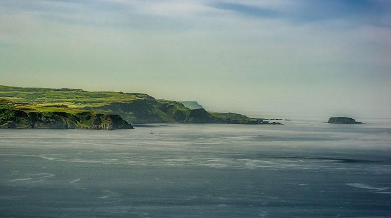 View across the sea to a green headland in the distance.