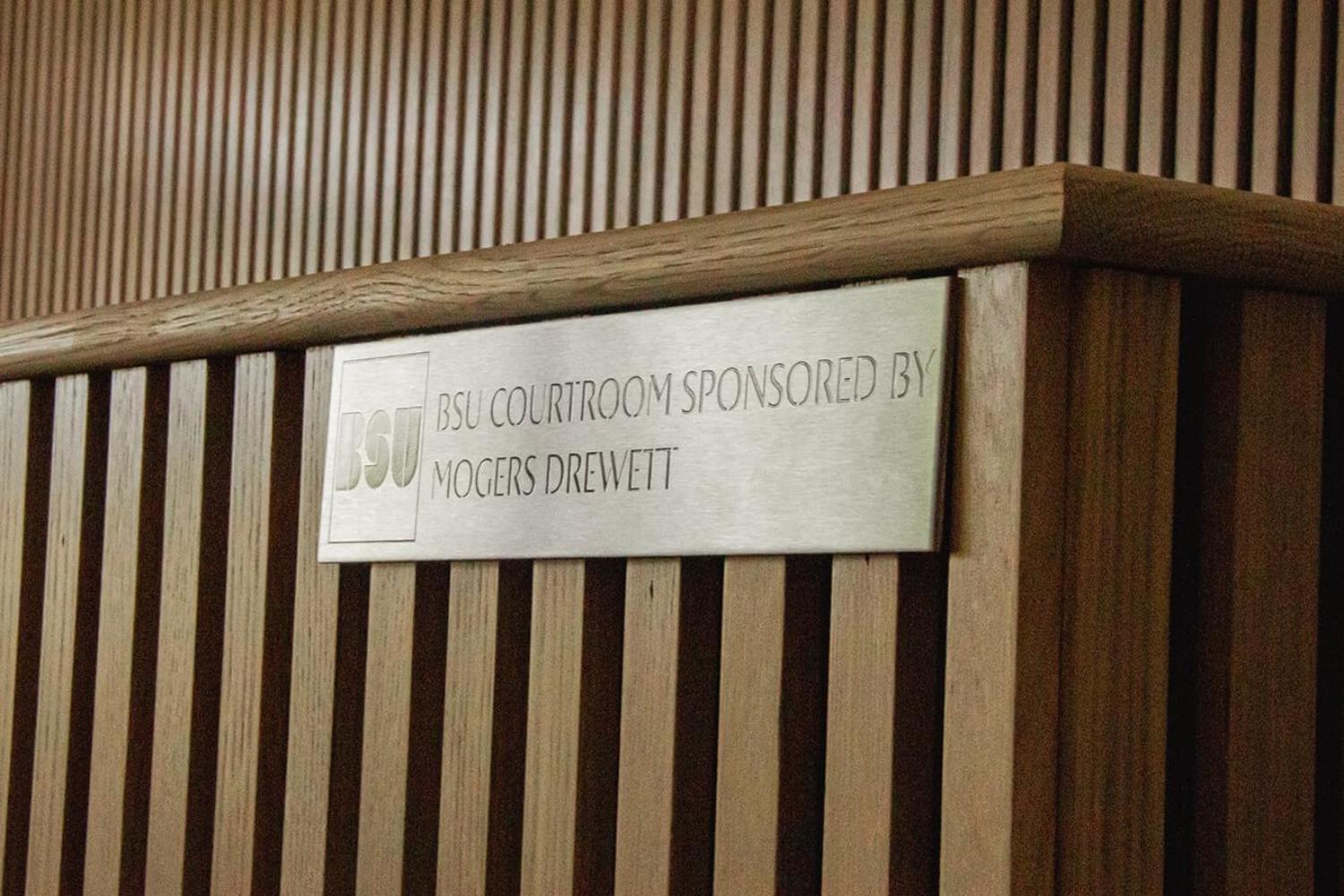 A close-up of a plaque that reads BSU courtroom sponsored by Mogers Drewett
