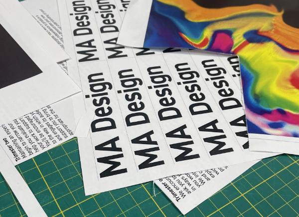 A sheet of paper on a table that says 'MA Design'