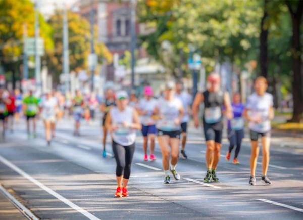 Marathon runners run along a city road