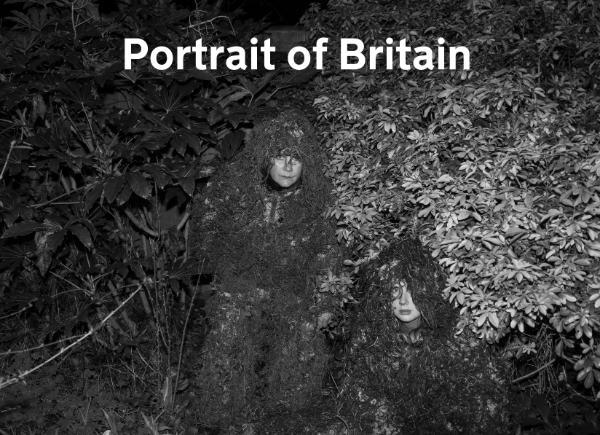 A portrait of Britain photograph showing two women in camouflage suits hiding in bushes