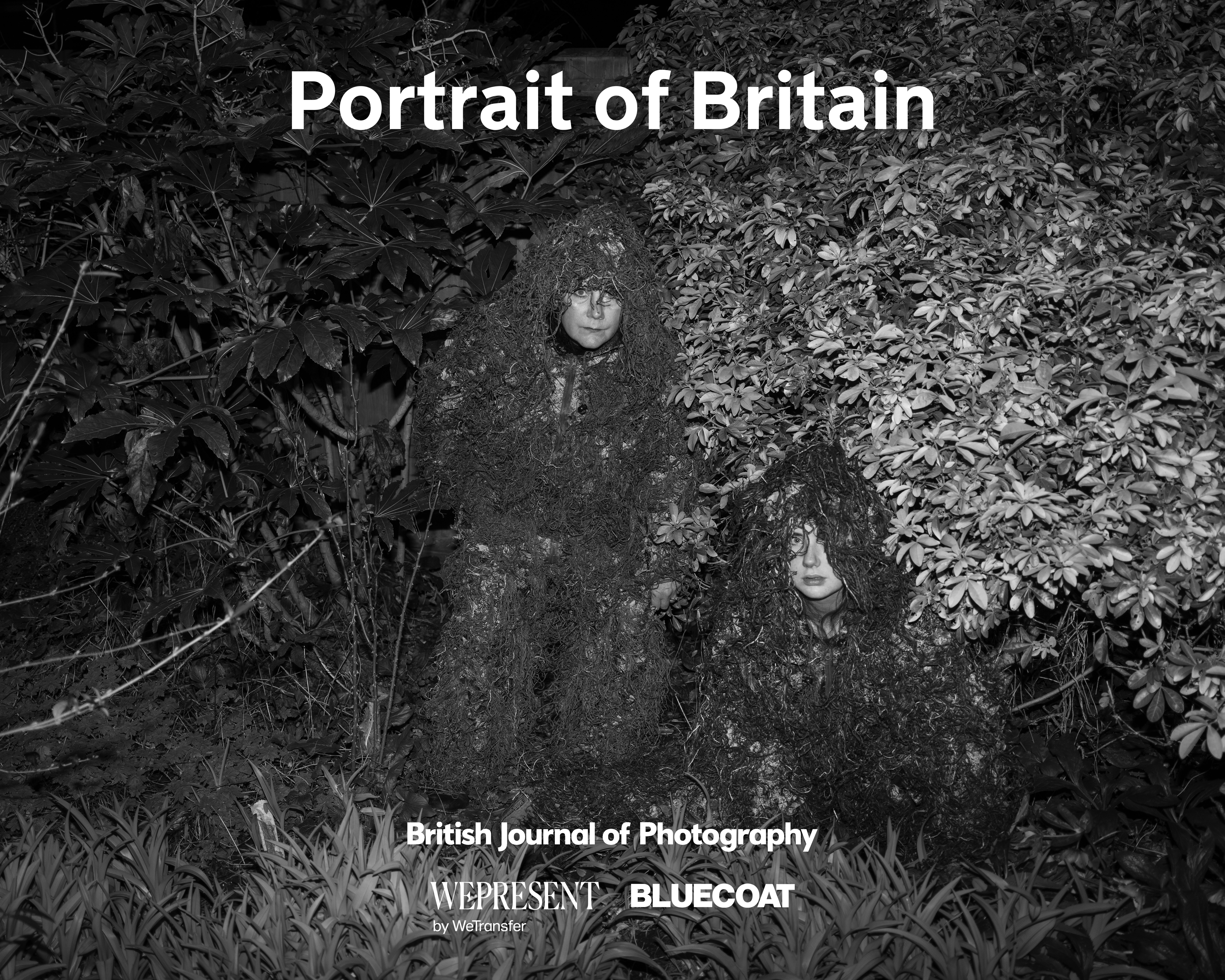 A portrait of Britain photograph showing two women in camouflage suits hiding in bushes