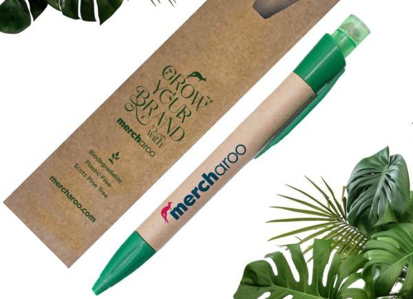 An eco-friendly pen with cardboard packaging, surrounded by green leaves