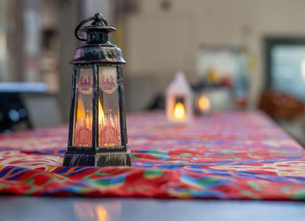 A lantern on a table with patterned cloth