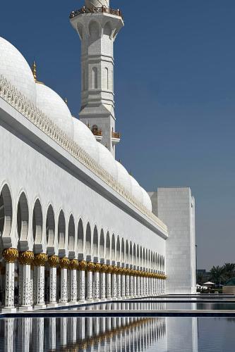 A mosque in Dubai with its reflection in a pool of water below
