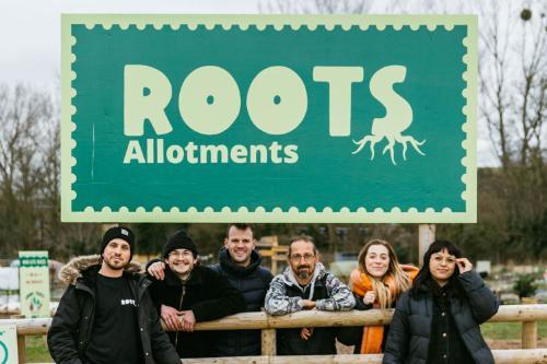 The Roots Allotments team posing under the Roots sign