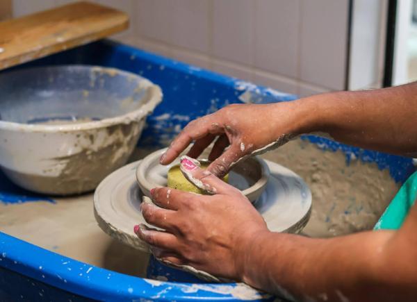 A person's hands molding clay