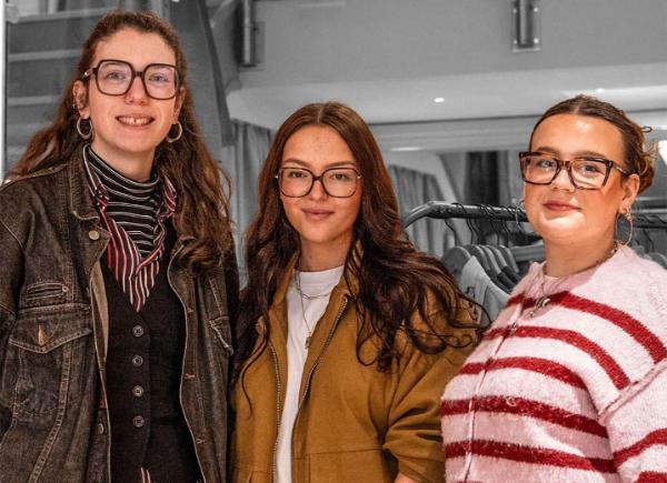 A group of three women smiling for a photo