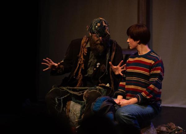 Two people performing on stage in colourful costumes