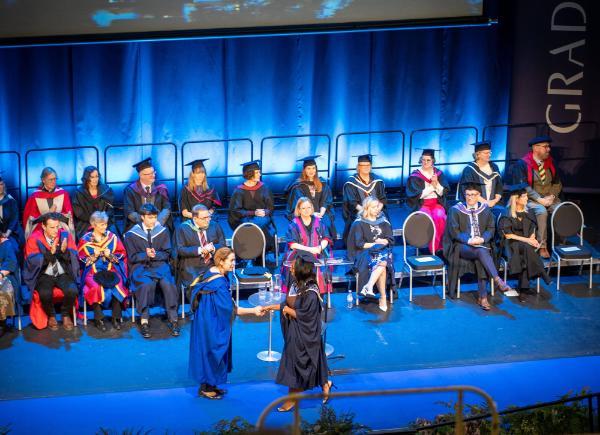 A graduate crosses the stage at The Forum