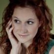 Headshot of a woman with reddish hair looking thoughtfully into the distance