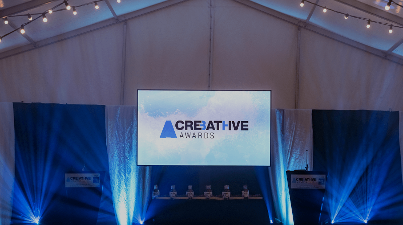A empty stage with a screen displaying the logo for the Creative Bath Awards.