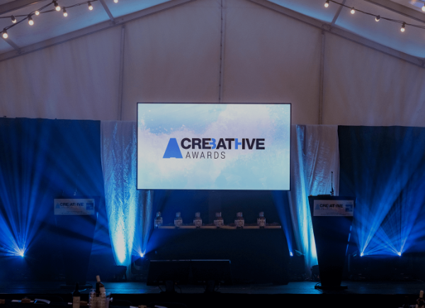 A empty stage with a screen displaying the logo for the Creative Bath Awards.