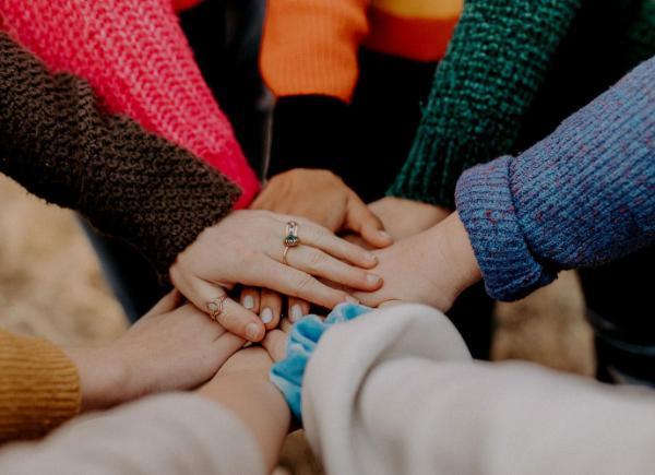 Hands of different ethnicities reaching out to each other