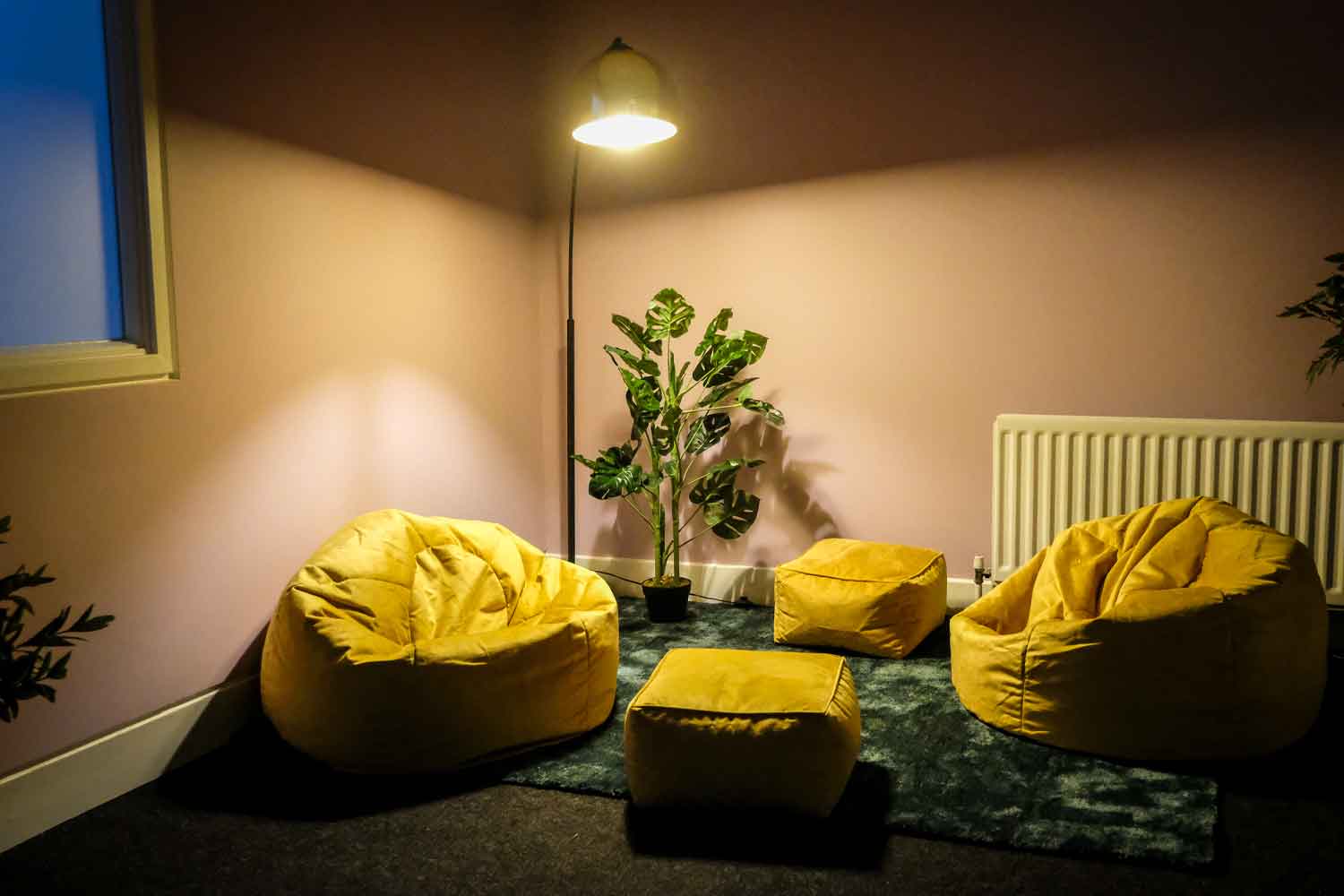 Photograph of room with yellow seats and cosy lighting