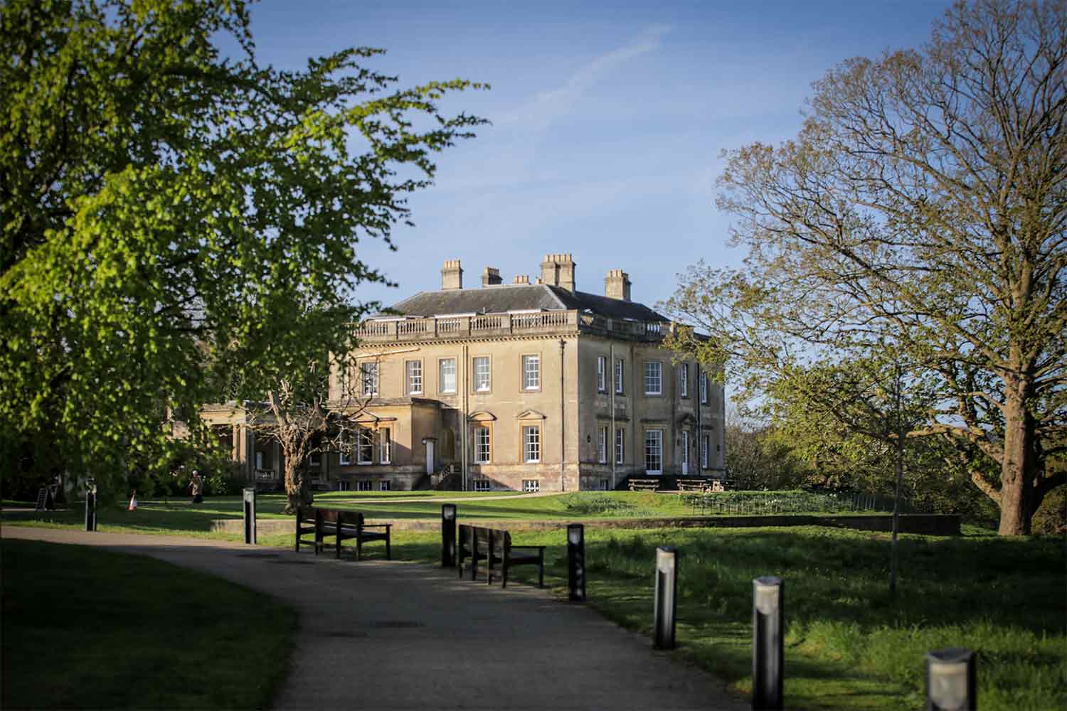 Shot along a bath through parkland towards a Georgian manor house