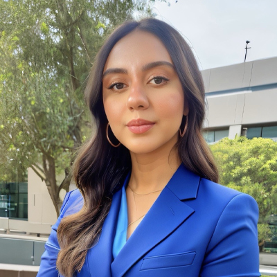 Headshot of someone with long dark hair wearing royal blue blazer