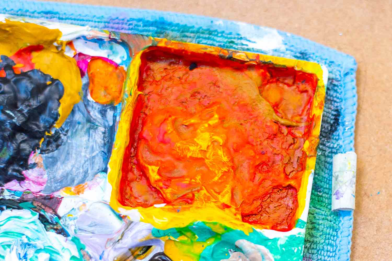Close up of artist palette showing orangey paint