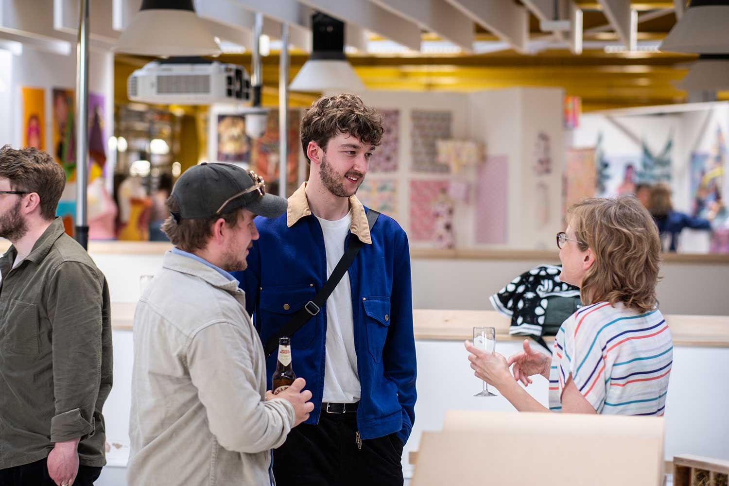 Three people having a conversation at an art exhibition