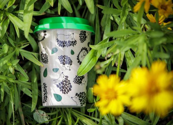 A reusable coffee cup lying on grass