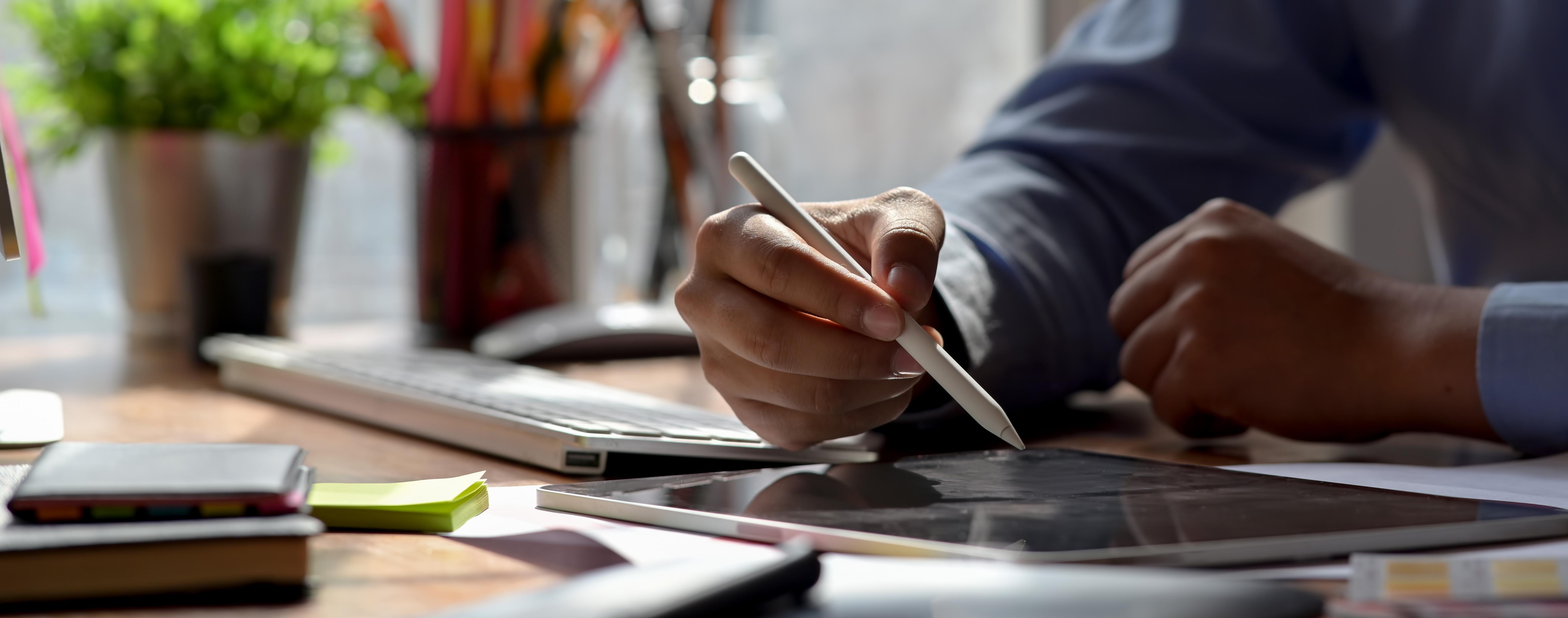 A close up of someone drawing on a digital tablet