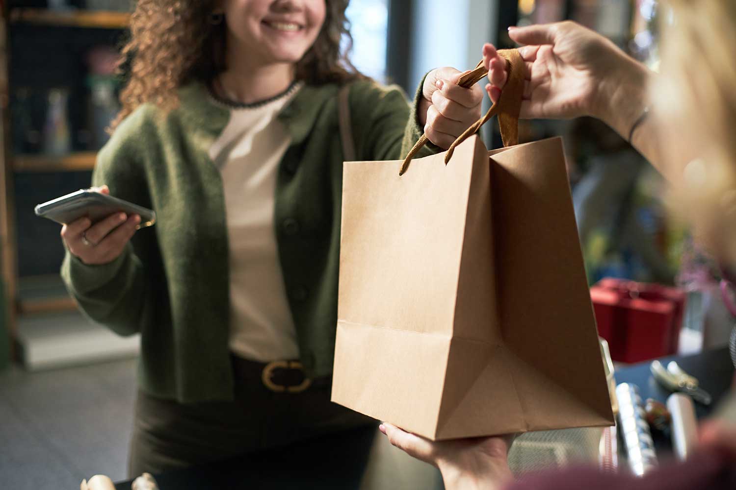 A person takes a shopping bag from a cashier