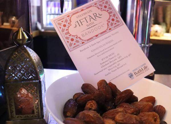 Bowl of dates with a printed menu and lantern