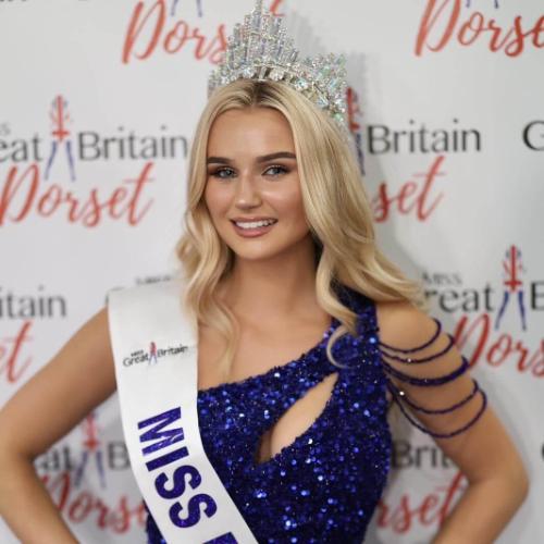 a blonde girl on a pageant stage in a long red gown
