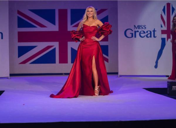 a blonde girl on a pageant stage in a long red gown