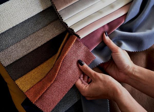 Hands holding an array of printed fabrics