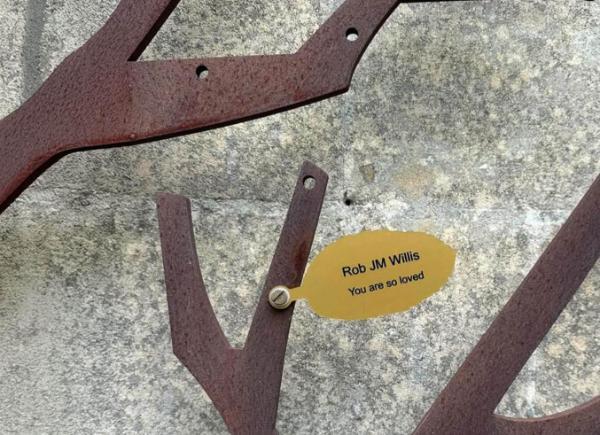 A student gold leaf on a metal memorial tree