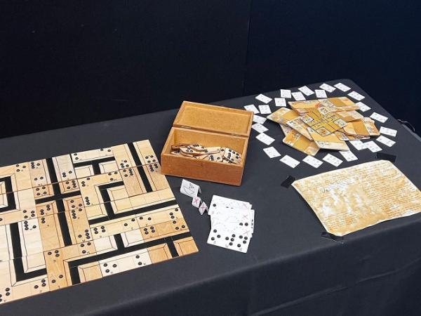 boardgame pieces laid out on a table with a black tablecloth and backdrop.