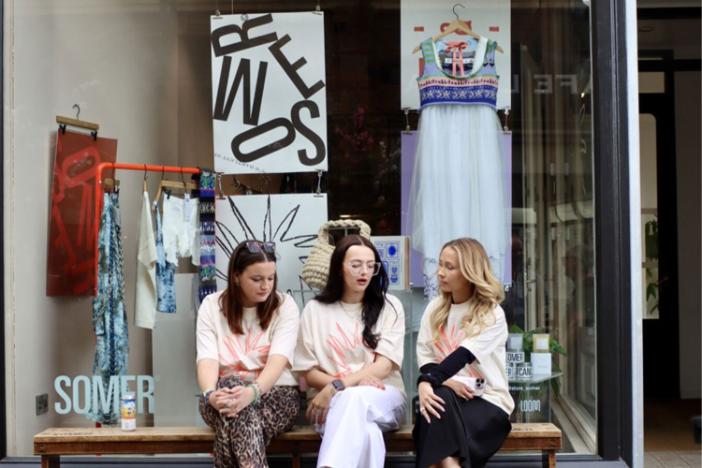 Three people sat outside the Somer store