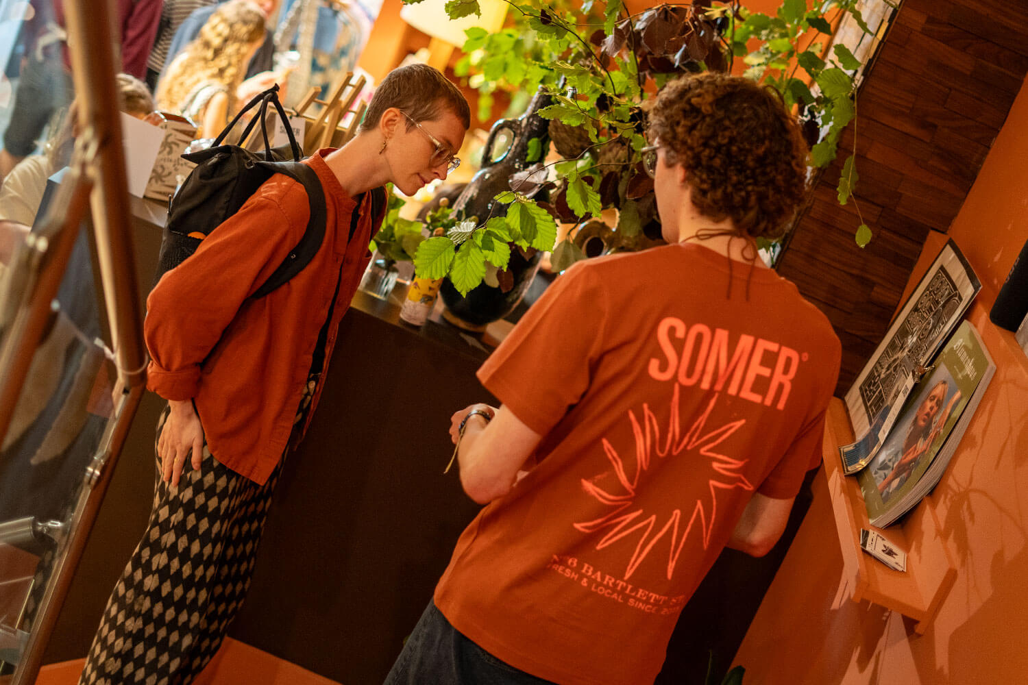 Two people stood inside a store talking on a staircase