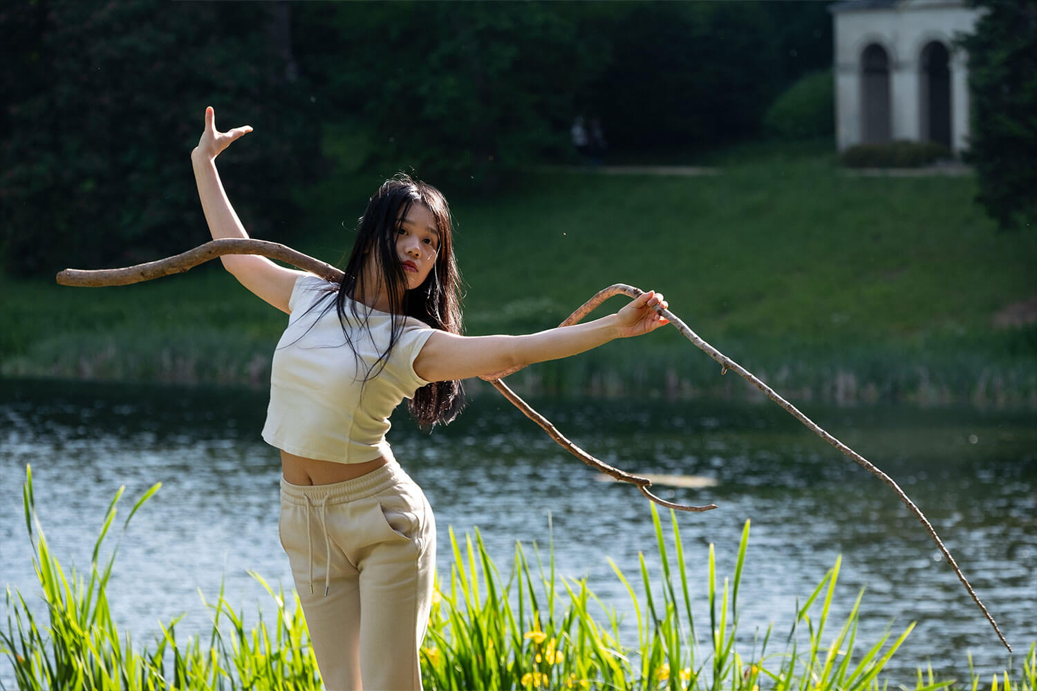a woman dancing in front a lake