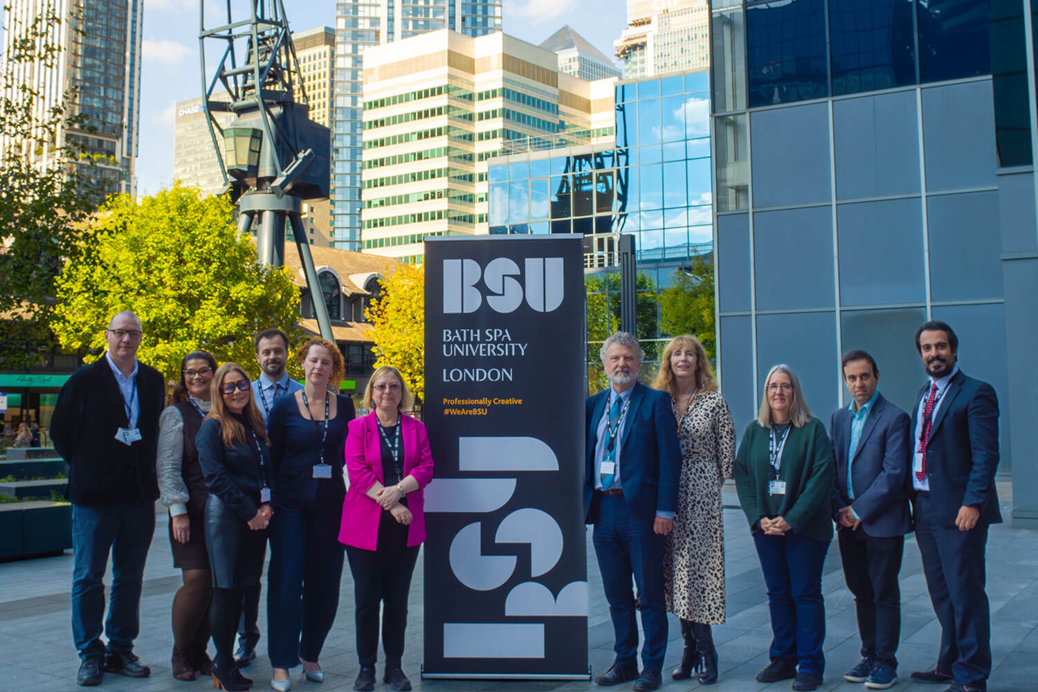 a group of people stood in front of a large banner