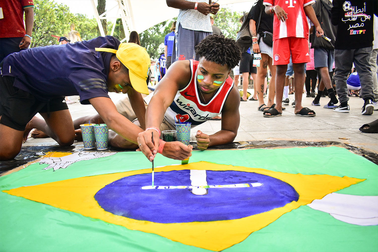 a person painting on a Brazilian flag