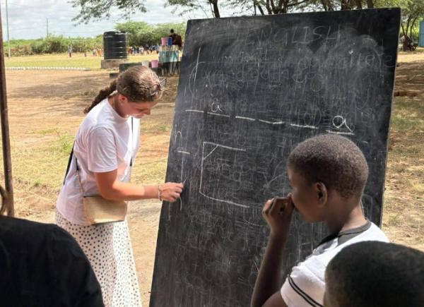 A student writing on a chalkboard
