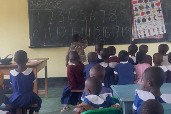 a group of young students writing on a chalkboard