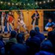 Performers on outdoor stage with musical instruments