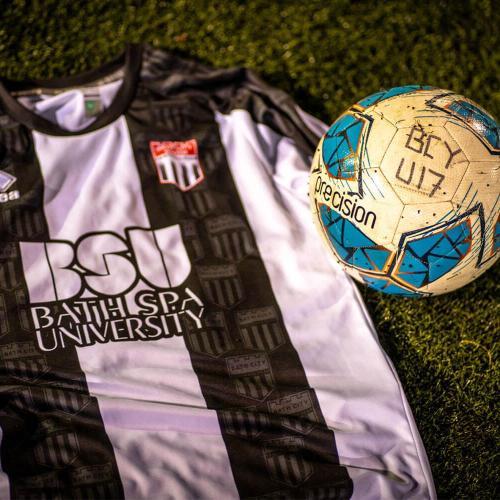 A football shirt and football on a grass pitch