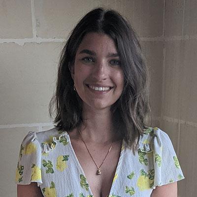 Young woman with shoulder length brown hair and floral blouse.