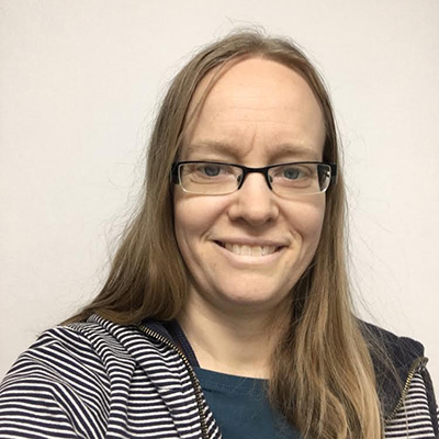A Bath Spa University staff member stands in front of a light background.