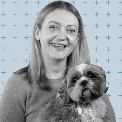 Headshot of person with long blonde hair holding a shih tzu dog