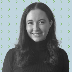 A person with dark hair smiles at the camera