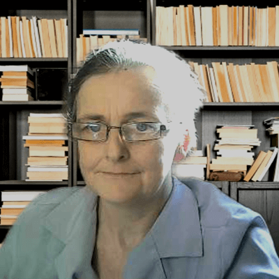 tracey edwards sits in front of two bookshelves