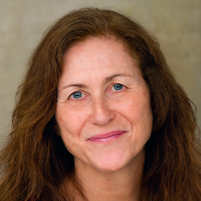 Person with long auburn hair smiling
